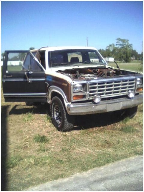 1980 Ford Bronco - 1980 Ford Bronco with its hood open and driver door ajar, parked outdoors.