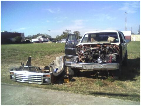 1980 Ford Bronco - A truck is disassembled with its front end and engine removed, parked on the side of a road.