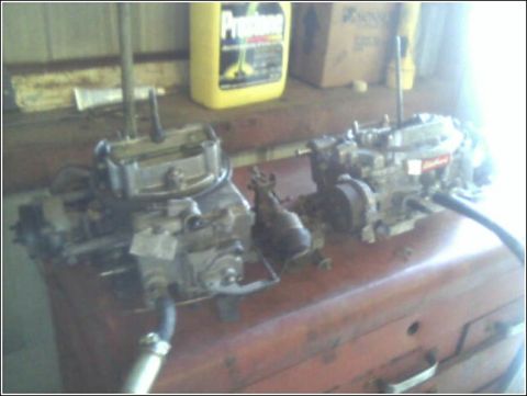 1980 Ford Bronco - Two carburetors are shown on a workbench, with one clearly displaying an Edelbrock label.