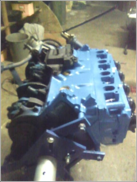 1980 Ford Bronco - A blue engine block is shown with various black mechanical parts attached.