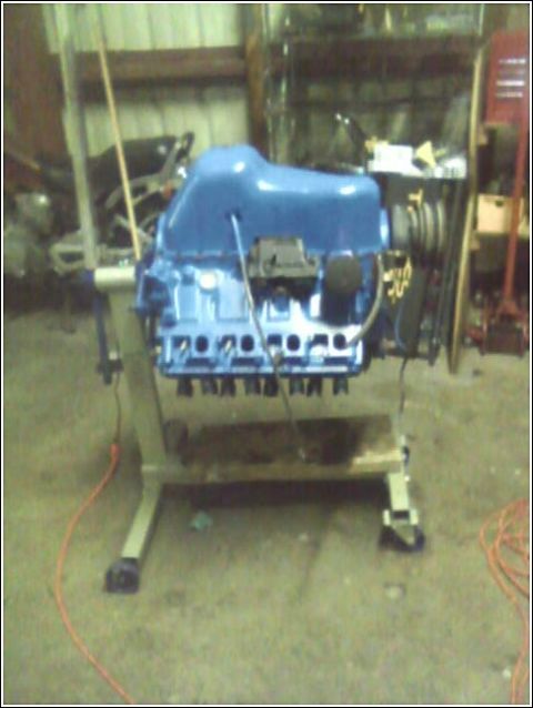 1980 Ford Bronco - Engine on a stand, possibly for a 1980 Ford Bronco, in a workshop setting.