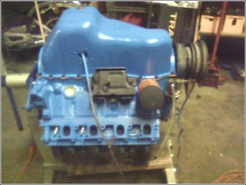 1980 Ford Bronco - Engine assembly with blue paint and various components visible, including the oil pan and pulleys.