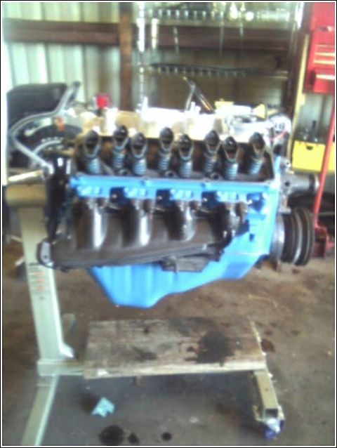 1980 Ford Bronco - Engine assembly on a stand in a workshop setting.