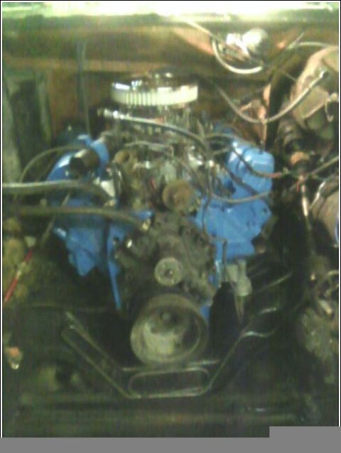 1980 Ford Bronco - Engine bay view of a blue engine with a chrome air filter and various hoses and wires.