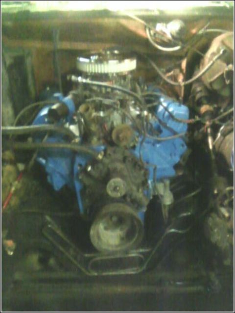 1980 Ford Bronco - Close-up view of an engine bay, showing the engine block painted blue and a chrome air filter assembly.