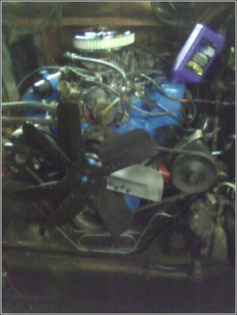 1980 Ford Bronco - Engine compartment with a blue engine block, chrome air filter, and a black fan visible.