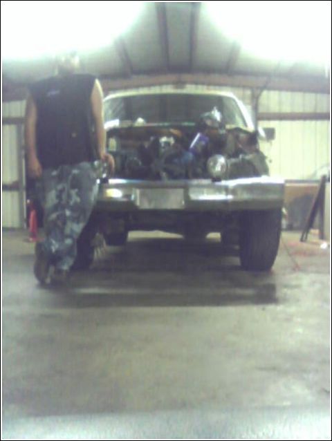 1980 Ford Bronco - A person stands next to a 1980 Ford Bronco with its hood open, revealing the engine.