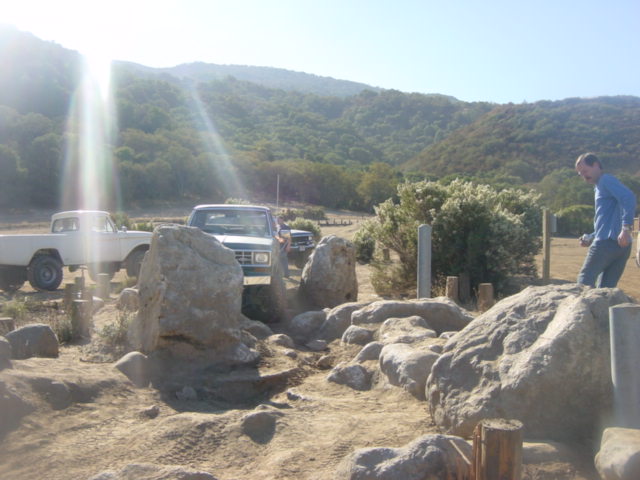 1986 Ford Bronco II and a white pickup truck navigating a rocky trail