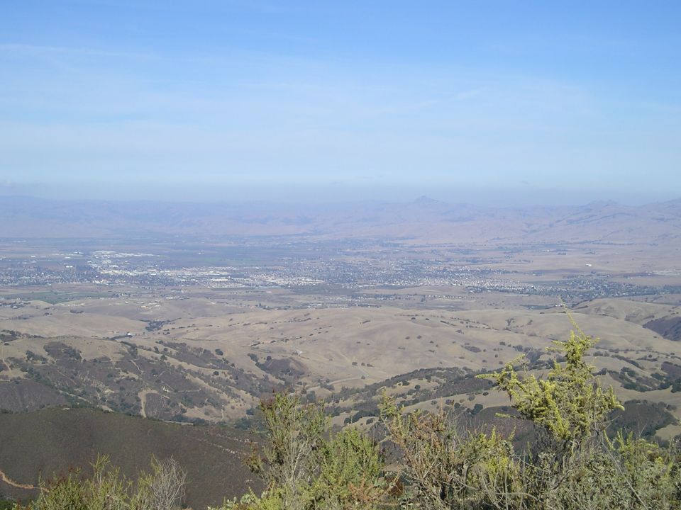 Vista of a valley and distant city with Supermotors logo