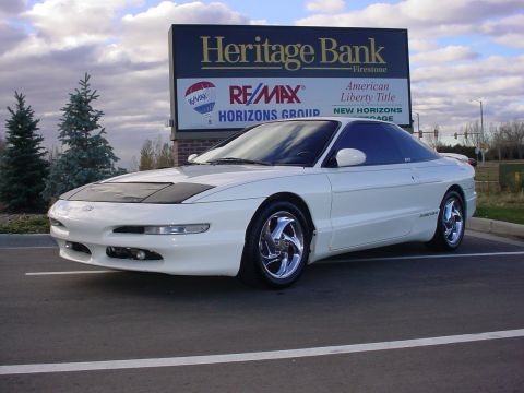 1996 Ford Probe - A white 1996 Ford Probe is parked in front of a Heritage Bank and Re/Max sign.