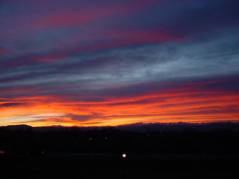 1996 Ford Probe - A dramatic sunset paints the sky with fiery colors above a distant mountain horizon.