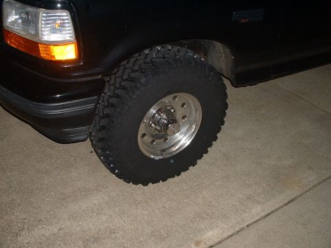 1994 Ford Bronco - Close-up view of the front wheel and fender of a black Ford Bronco.