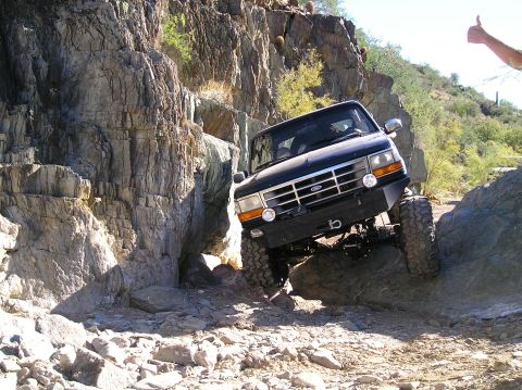 1993 Ford Bronco - Ford Bronco tackles a challenging off-road course on a sunny day.