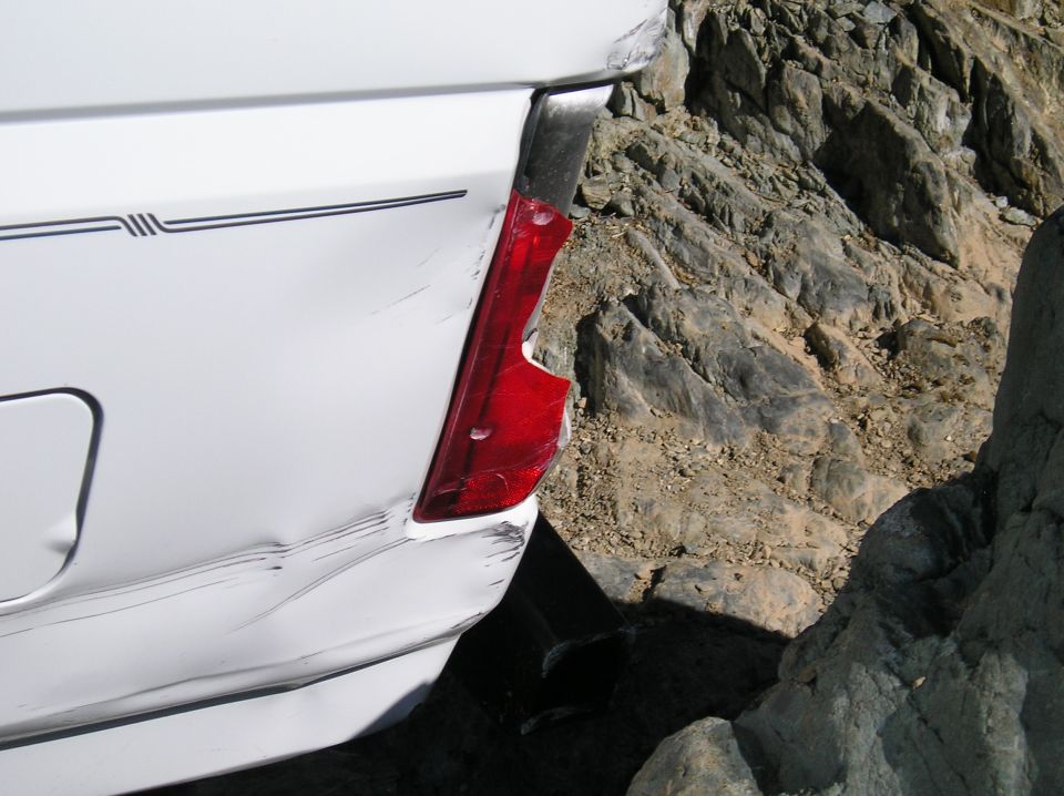 White 1993 Ford Bronco rear quarter panel with damaged taillight and bodywork