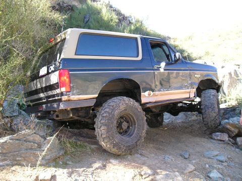 1993 Ford Bronco - Ford Bronco tackles a challenging off-road course with its modified suspension and aggressive tires.