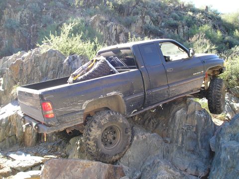 1993 Ford Bronco - This black pickup truck navigates a challenging rocky trail, its off-road capabilities.