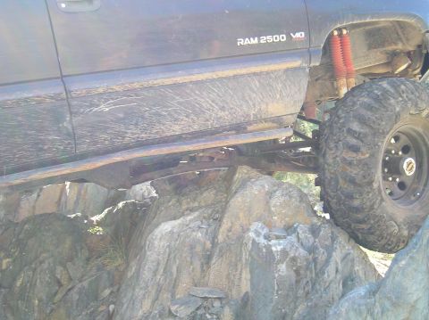 1993 Ford Bronco - Dodge Ram 2500 off-roading on a rocky terrain, showing its suspension and large tires.