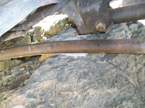 1993 Ford Bronco - Undercarriage components are visible, with rocks lodged between them.