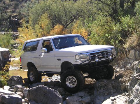 1993 Ford Bronco - This lifted 1993 Ford Bronco tackles a challenging rocky path, its off-road capabilities.