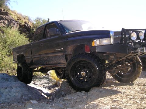 1993 Ford Bronco - This black Dodge Ram 2500 is navigating a challenging rocky trail.