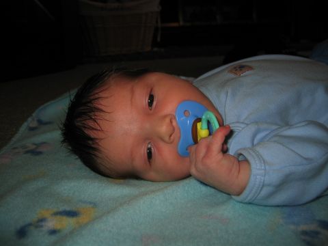 2002 Ford Taurus - Baby with a blue pacifier on a patterned blanket, with a Supermotors logo visible.