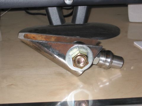 1991 Ford Explorer - A close-up view of a metal bracket assembly, likely a vehicle part, resting on a wooden surface.