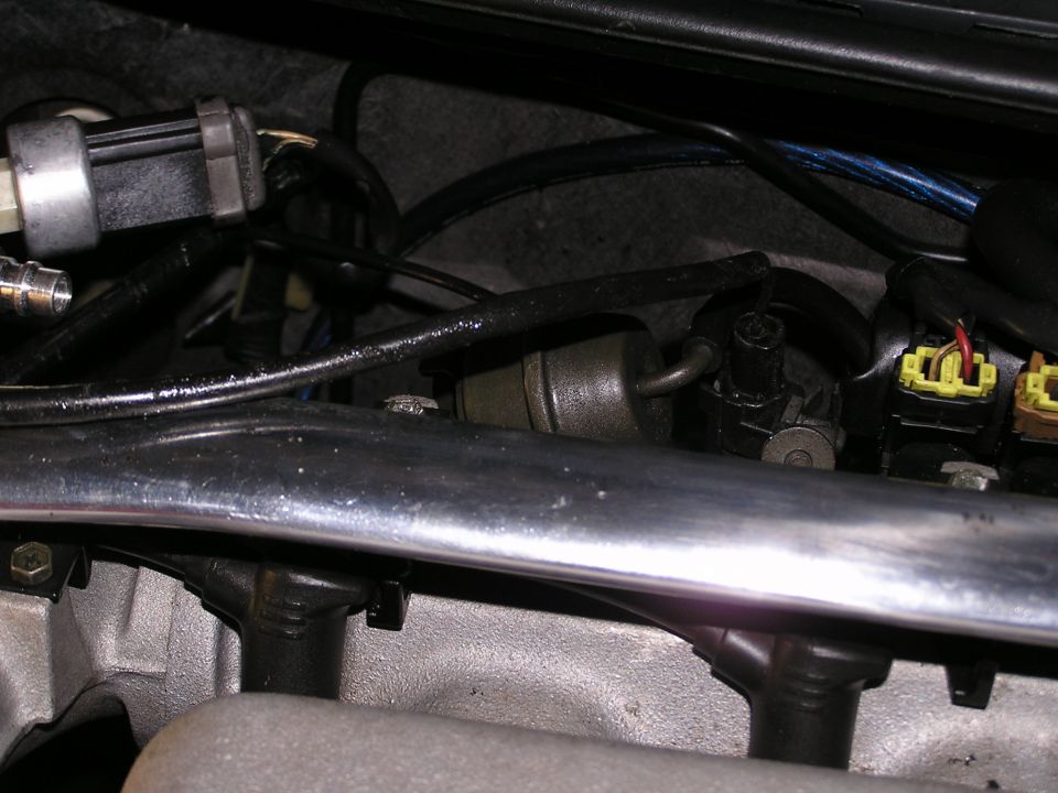 Close-up of engine bay parts including fuel injectors and wiring
