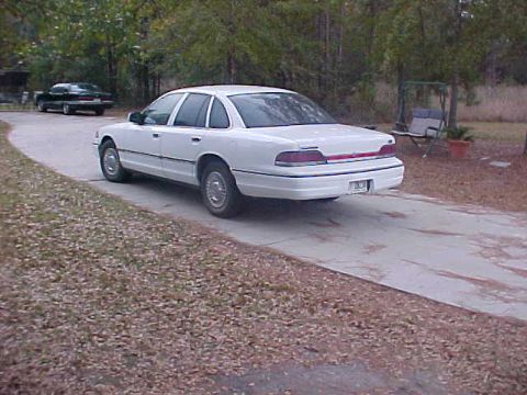 1993 Ford Crown Victoria - White 1993 Ford Crown Victoria seen from the rear on a paved driveway.