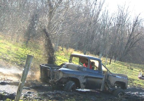 1978 Ford Bronco - A mud-caked 1950s Chevrolet Task Force stepside pickup blasts through a rutted mud pit, throwing a tall rooster tail of muck behind the bed…
