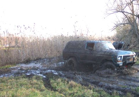1978 Ford Bronco - This SUV is deep in the mud, with a second vehicle partially visible in the background.