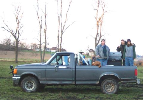 1978 Ford Bronco - Full side profile of a gray 1987-91 Ford F-Series regular-cab long-bed 4x4 pickup parked in a muddy field, with an "OUTLAW" decal on the do…
