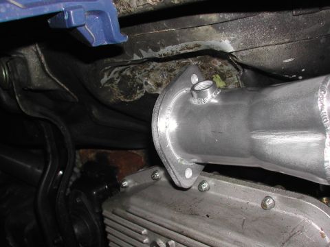 1993 Ford Thunderbird - Detail of an exhaust system connection to an engine part, with visible text from SuperMotors.net.