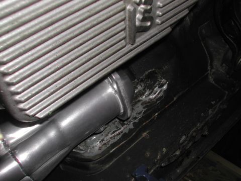 1993 Ford Thunderbird - Close-up view of an exhaust pipe connection to a vehicle's engine block.