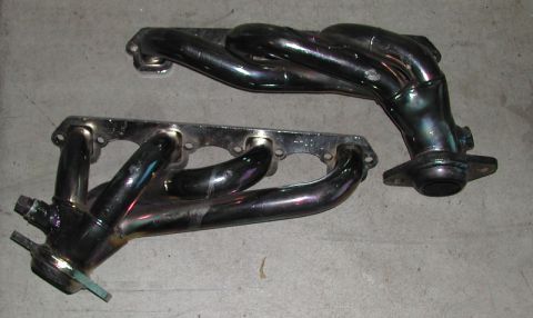 1993 Ford Thunderbird - Pair of aftermarket exhaust manifolds shown on a gray surface.