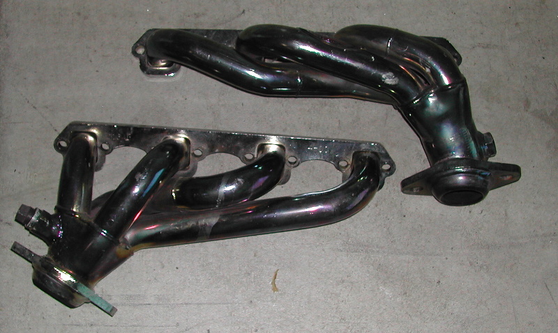 Two chrome exhaust manifolds on a concrete surface