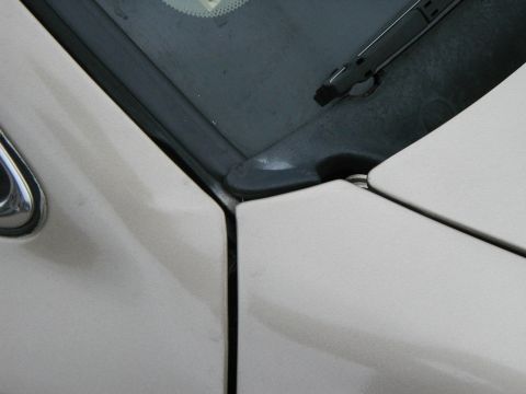 1999 Ford Crown Victoria - Close-up view of the seam between a car's door and the windshield frame.
