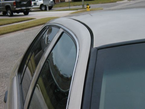 1999 Ford Crown Victoria - Side profile of a silver 1999 Ford Crown Victoria, showing its distinctive body style.