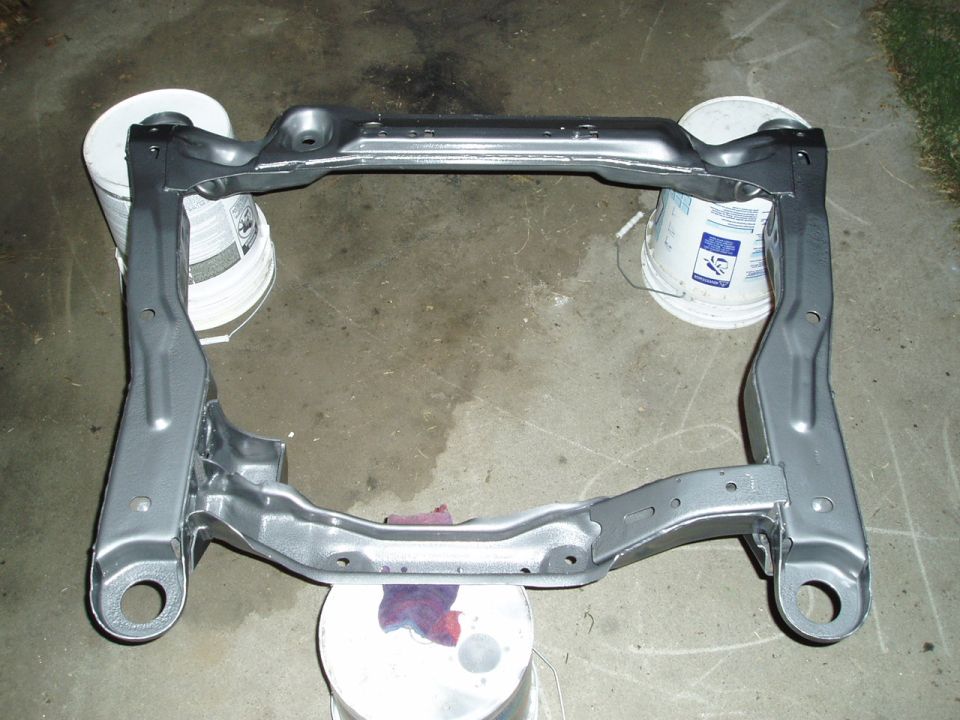 Gray painted automotive subframe supported by buckets