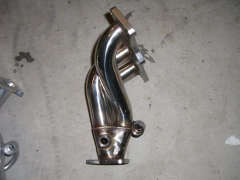 1996 Ford Probe - A close-up view of a polished exhaust manifold, a component of a vehicle's exhaust system.