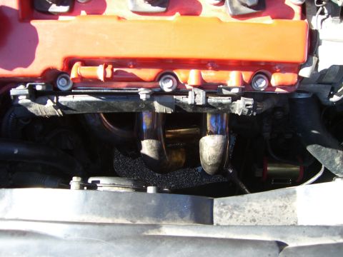1996 Ford Probe - Engine exhaust manifold pipes and red valve cover are visible in this close-up view.