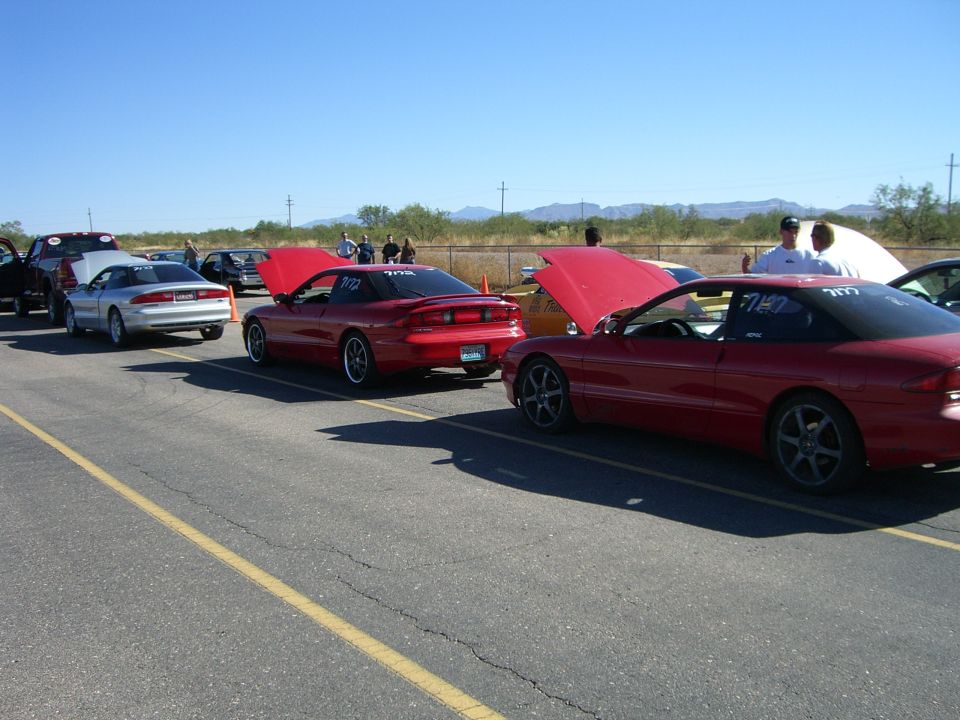 Red 1996 Ford Probe with hood up, rear 3/4 view