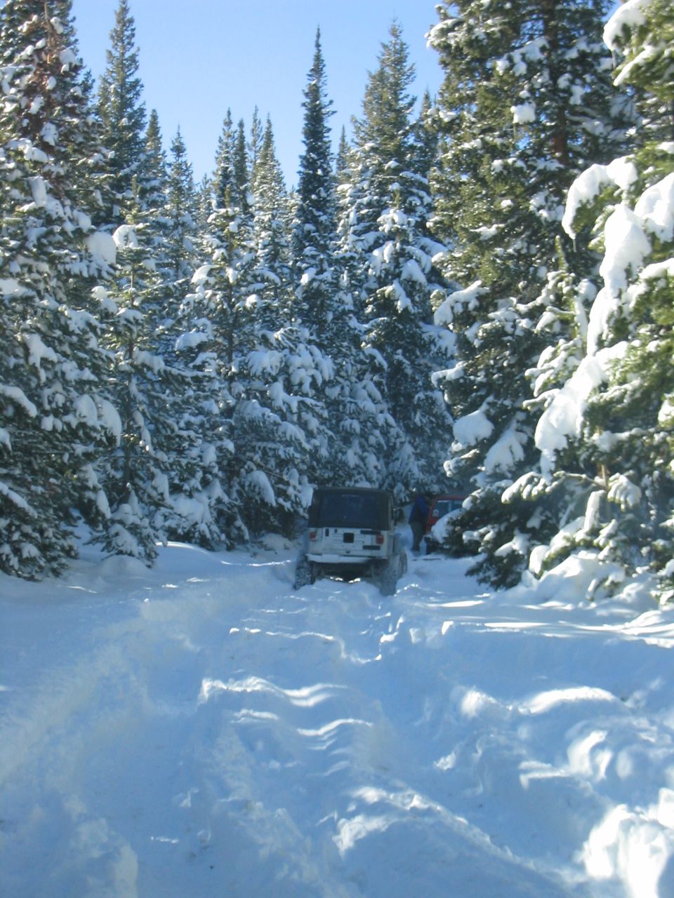 1997 Jeep Cherokee driving through deep snow on a forest road