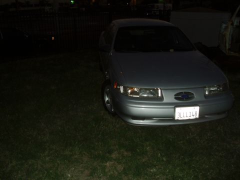 1993 Ford Taurus - Front view of a silver Ford Taurus, likely a 1996 model, parked on grass at night.