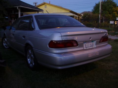 1993 Ford Taurus - Rear view of a silver 1993 Ford Taurus sedan parked on a grassy lawn.