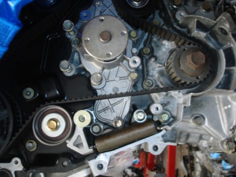 1993 Mazda MX-3 - Close-up view of an engine's timing belt, water pump, and tensioner assembly.