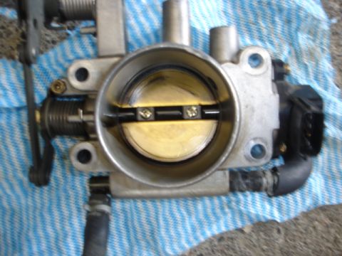1993 Mazda MX-3 - Close-up of a throttle body assembly, likely removed for cleaning or repair.