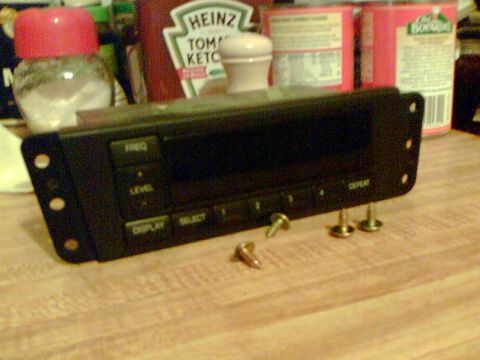 1997 Ford Probe - A car stereo unit with various buttons and a digital display sits on a wooden surface.