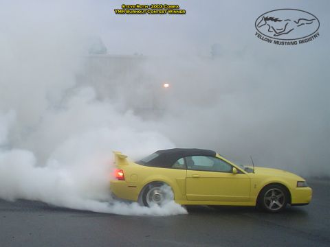 1986 Ford Bronco - A yellow convertible sports car performs a burnout, creating a large cloud of smoke. The image is labeled as a 2003 Cobra and a burnout con…