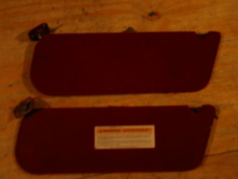 1994 Ford Bronco - Maroon sun visors are shown on a wooden surface.
