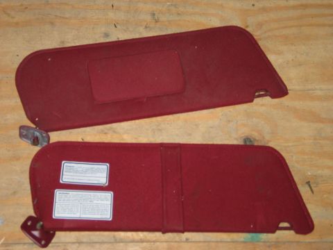 1994 Ford Bronco - Two red sun visors are shown, each with mounting hardware attached to the sides.